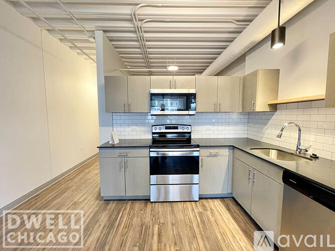 A modern kitchen with wooden floors and stainless steel appliances.