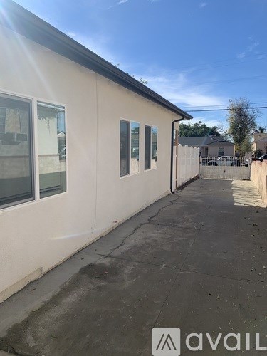 A white building with a sunny sky in the background.