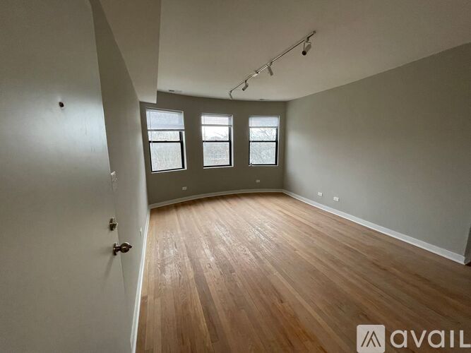 A room with wooden flooring and a window.
