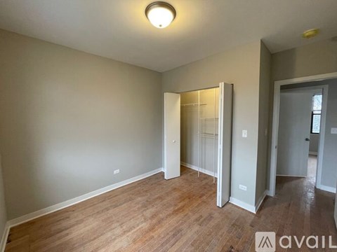 A room with wooden flooring and a white ceiling light.