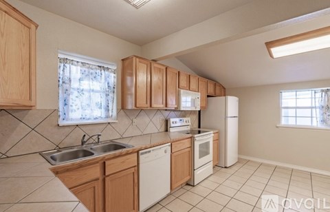 A kitchen with wooden cabinets and white appliances.