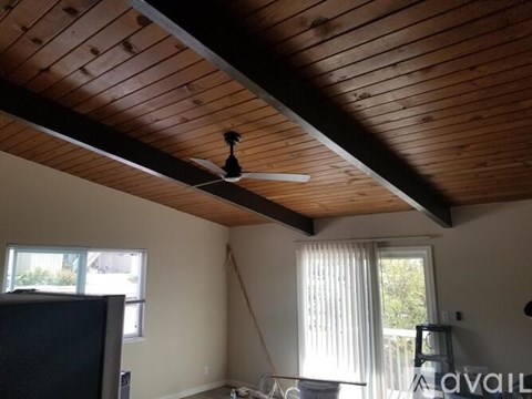 A room with a ceiling fan and a window.