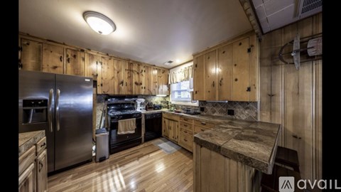 A kitchen with wooden cabinets and a stainless steel refrigerator.