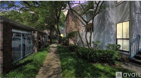 A narrow alley with a metal fence on the left and a building on the right.