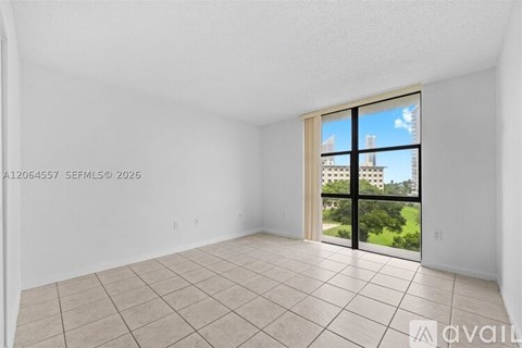 A room with a large window overlooking a building.