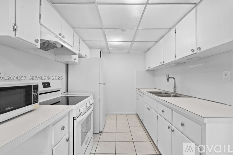A kitchen with white cabinets and appliances.