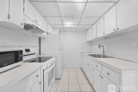 A kitchen with white cabinets and appliances.