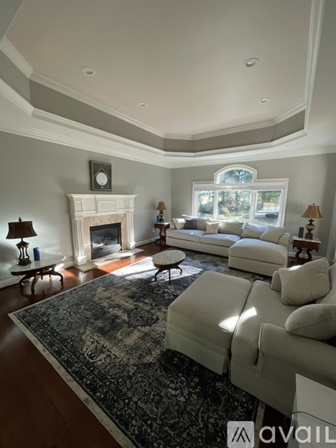 A living room with a fireplace and a large window.
