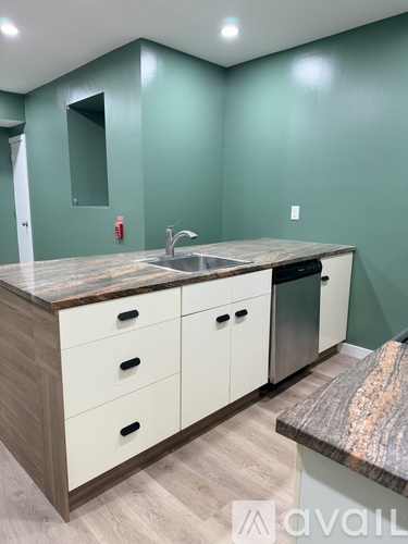 A kitchen with green walls and a marble countertop.