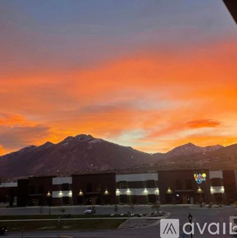 A mountain range is in the background of a building with a sunset sky.