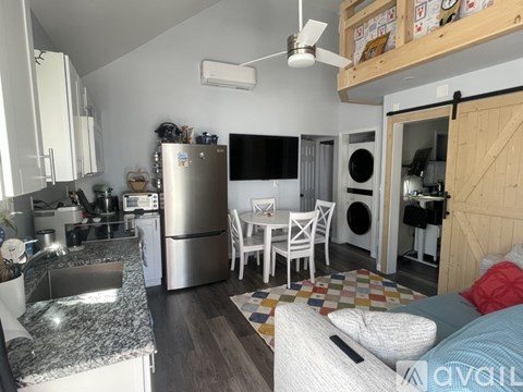 A white front loading washing machine is built into a cabinet in a laundry room.