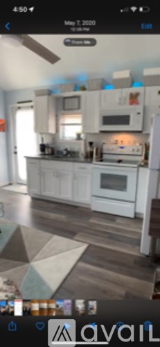 A kitchen with white cabinets and a wooden floor.
