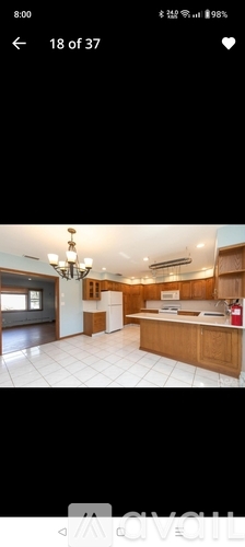A modern kitchen with wooden cabinets and a white tile floor.