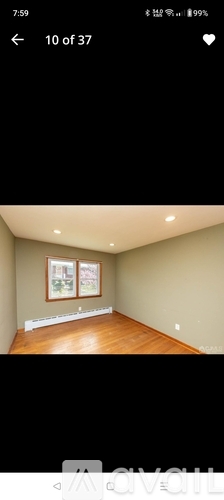 A room with a wooden floor and two pictures on the wall.