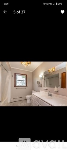 A bathroom with a white sink and a window.