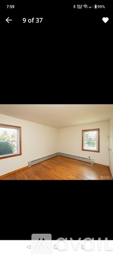 A room with wooden flooring and a window.