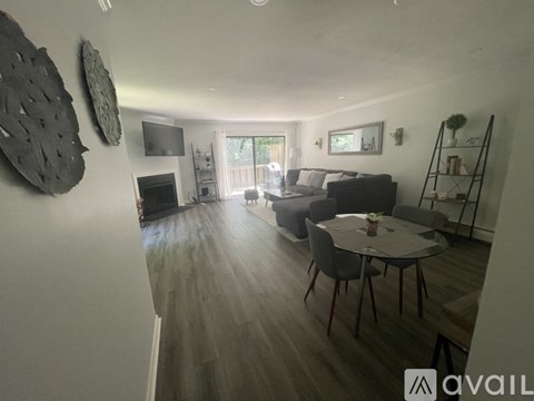 A living room with a grey couch, a coffee table, and a television.