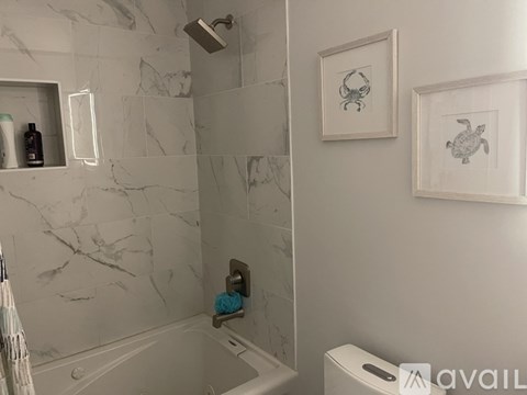 A bathroom with a marble wall and a white toilet.
