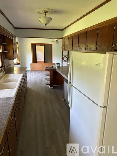 A kitchen with a white refrigerator and wooden cabinets.