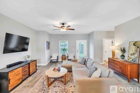 A living room with a black television and a wooden coffee table.