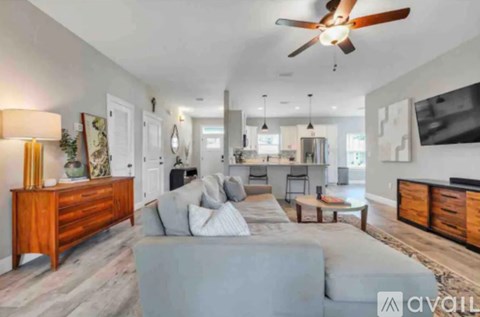 A modern living room with a grey sofa and a wooden sideboard.