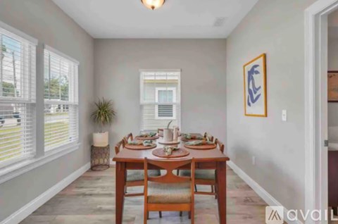 A dining room with a wooden table set for a meal.