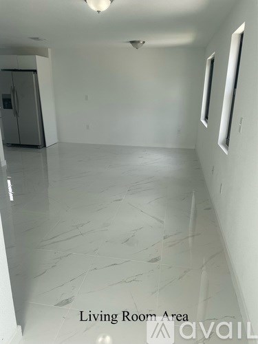 A living room area with a marble floor and white walls.