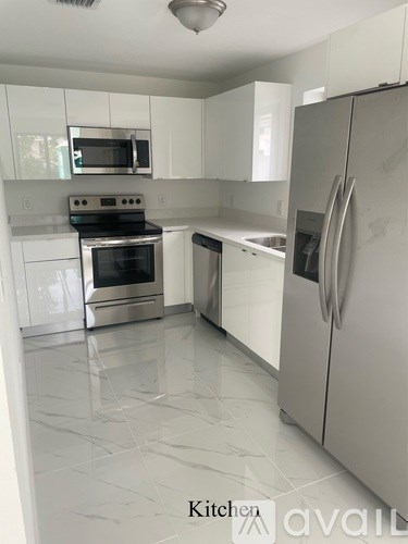 A kitchen with white cabinets and appliances.
