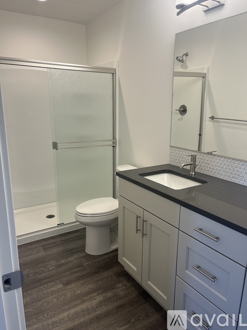 A bathroom with a toilet, sink, and walk-in shower.