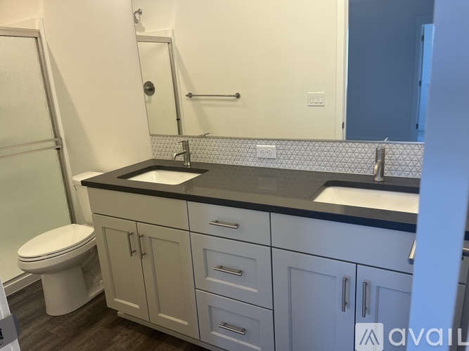 A bathroom with a toilet, sink, and shower.