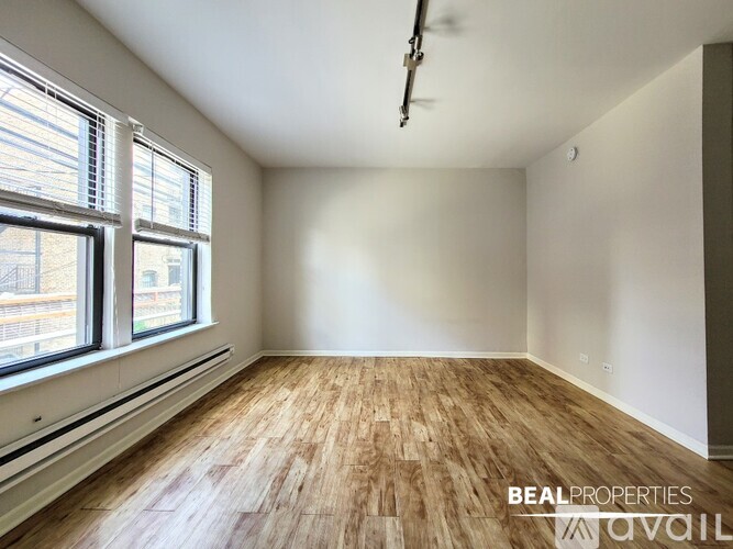 A room with wooden flooring and a ceiling fan is available for rent.