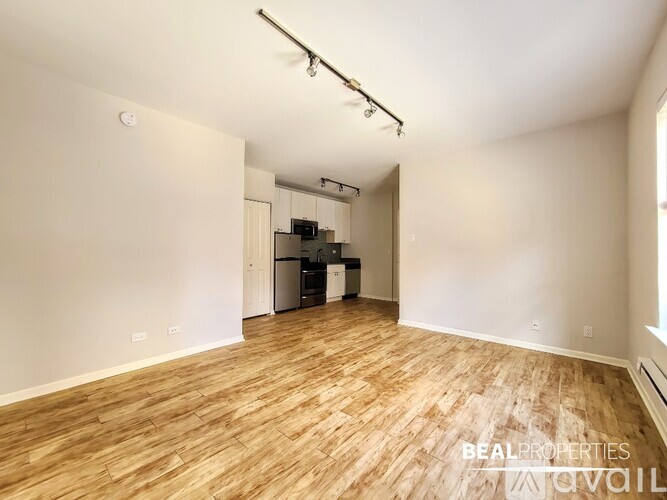 A room with wooden flooring and a white wall.