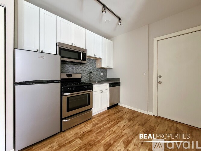 A kitchen with white cabinets and a wooden floor.