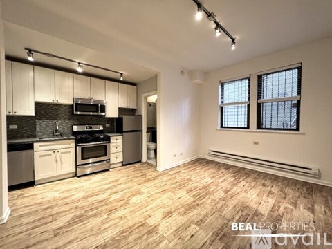 A kitchen with white cabinets and black countertops.