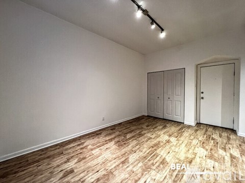 A room with wooden flooring and white walls.
