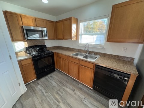 A kitchen with wooden cabinets and a black stove top oven.