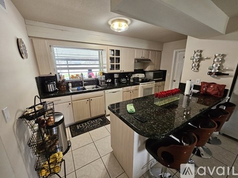 A kitchen with a black granite countertop and wooden cabinets.