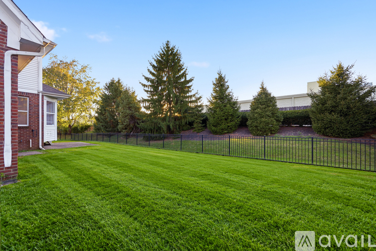 A backyard with a fence and trees.