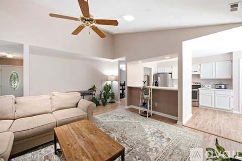 A living room with a beige couch and a wooden coffee table.