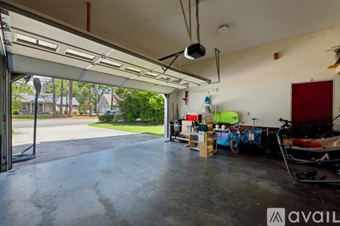 A spacious garage with a bicycle and a red door.