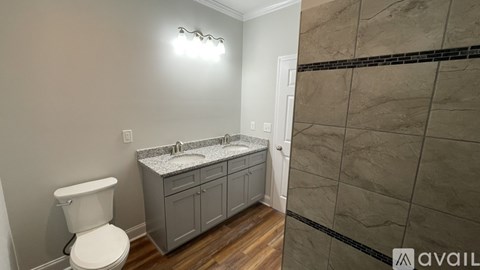 A bathroom with a toilet, sink, and cabinet.