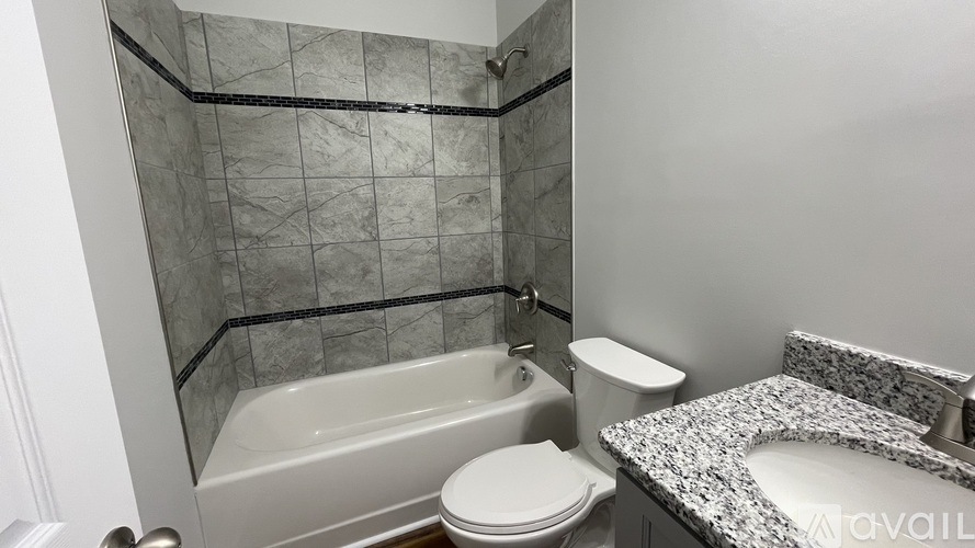 A bathroom with a marble countertop and a glass shower stall.
