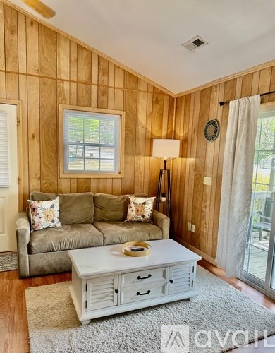 A living room with a couch, a coffee table, and a window.