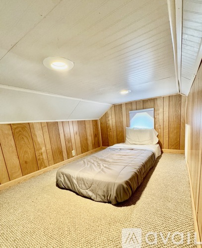 A bedroom with a bed and a window.