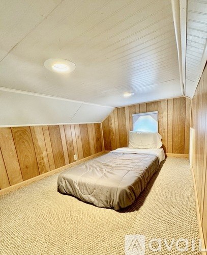 A bedroom with a bed and a window.