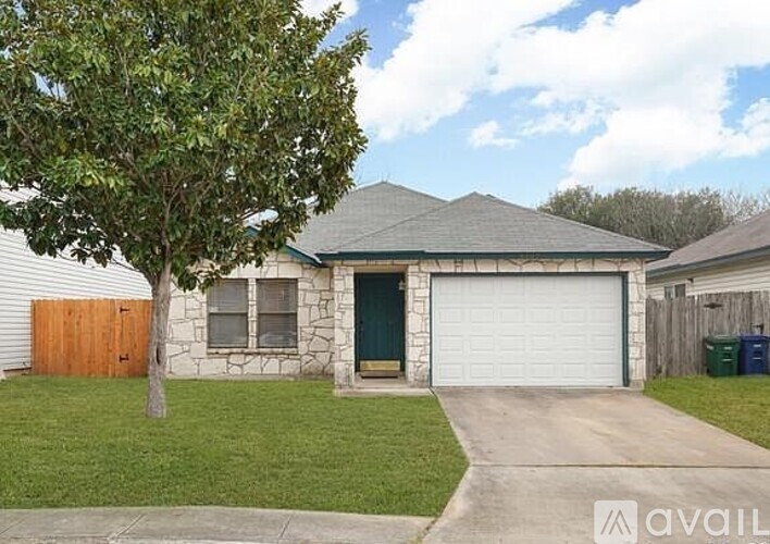 A house with a green door and a white garage door.