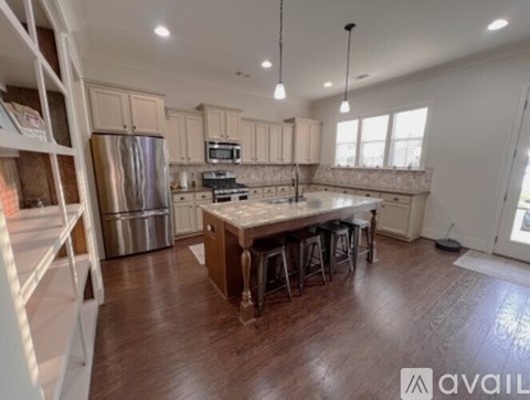 A kitchen with wooden floors and a large island in the middle.