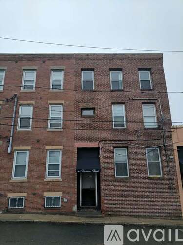 A brick building with a sign that says "avail" in front of it.