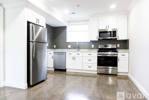 A kitchen with a refrigerator, oven, and microwave.
