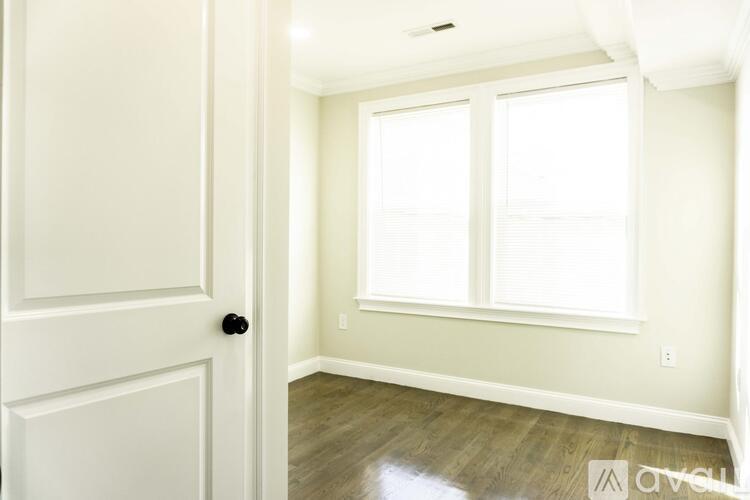 A white door is on the left and a window with blinds is on the right.